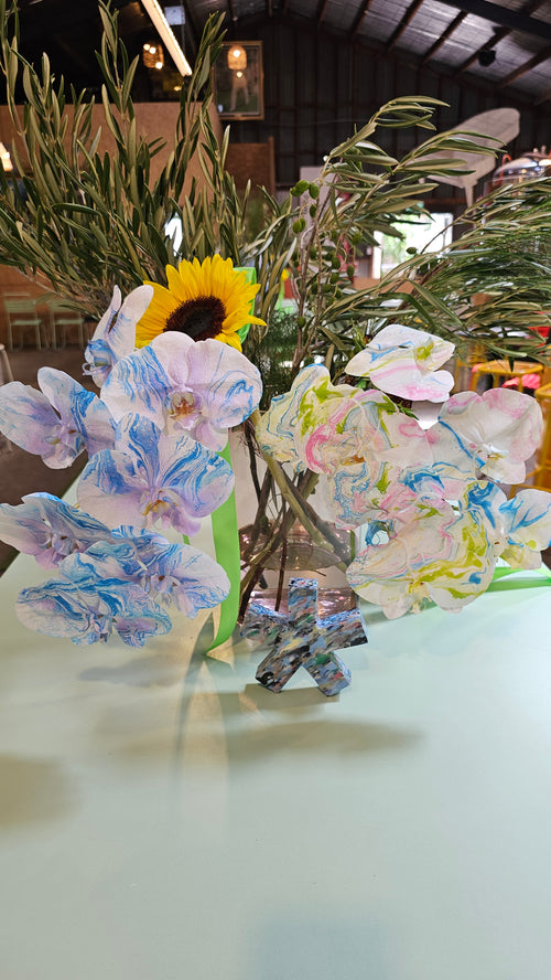 Decorative floral arrangement with colorful flowers on a white surface