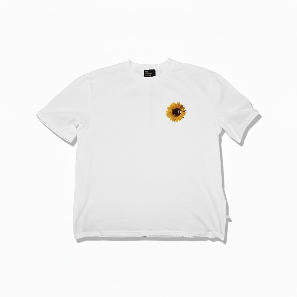 White t-shirt with a yellow sunflower design on the chest, flat laid on a white background